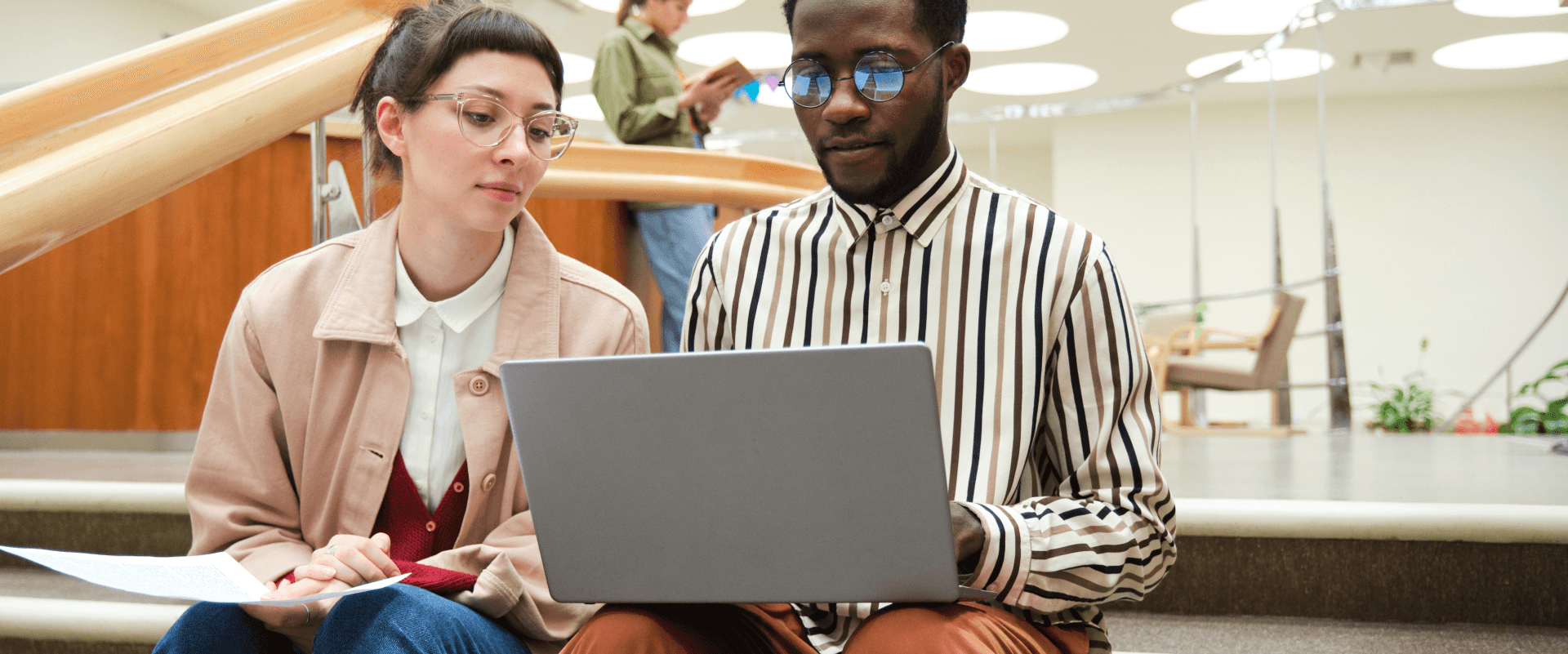 Researchers collaborating on a laptop in a library